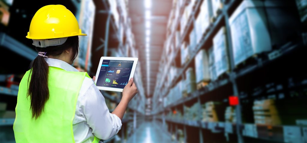 Worker in a warehouse holding a tablet for inventory management